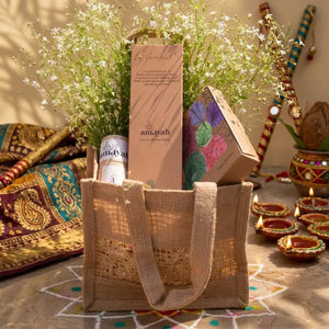 Reusable jute bag styled as a festive gift hamper for Diwali with home fragrance products.